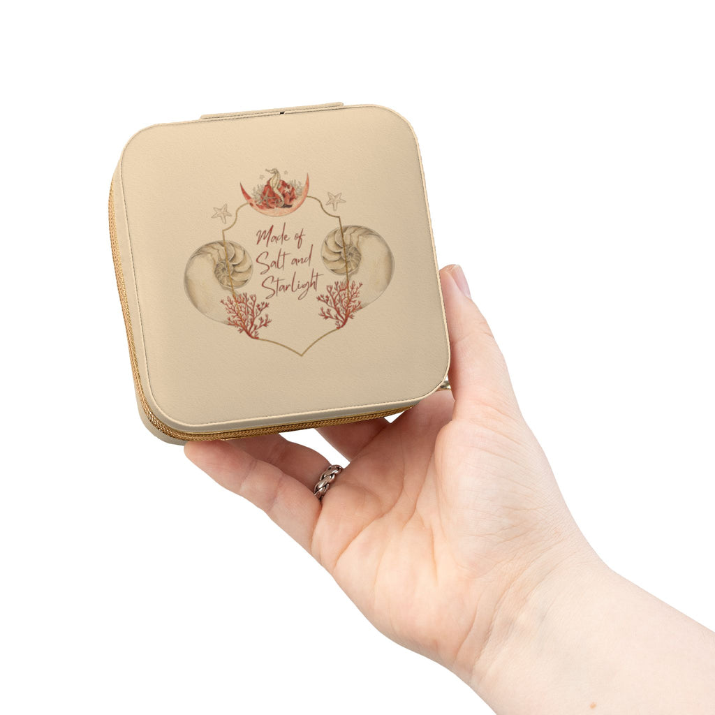 Salt & Starlight jewelry travel case in soft gold, held in hand showing the shell and coral design