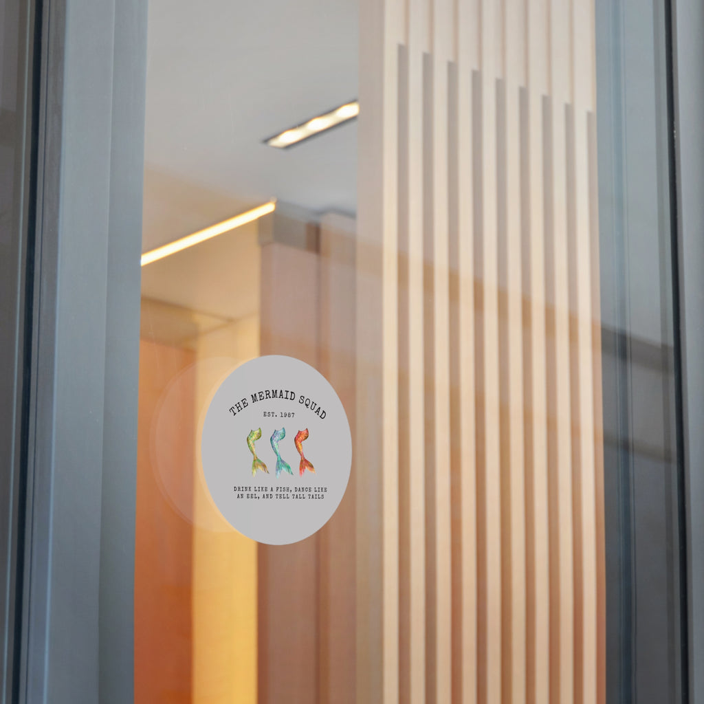 The Mermaid Squad round vinyl sticker in grey, shown on a glass door