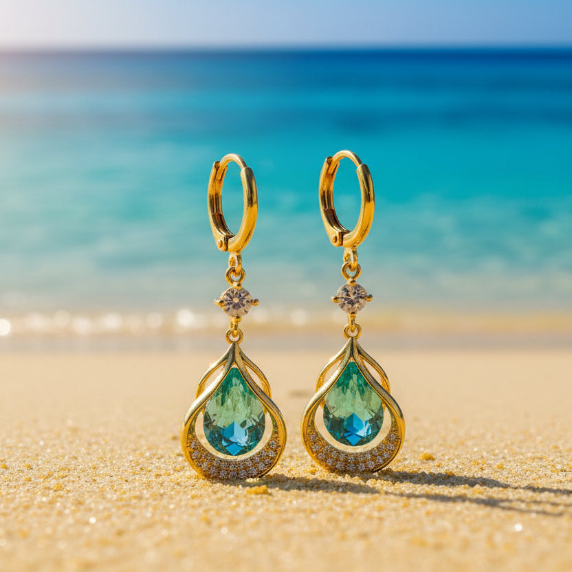 Gold earrings with green gemstones on a gradient background