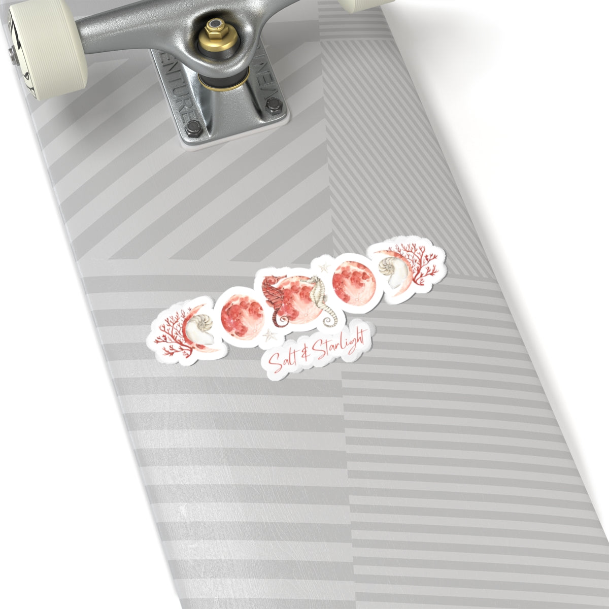 Salt & Starlight kiss-cut sticker with seahorse and coral moon phase design, shown on a longboard
