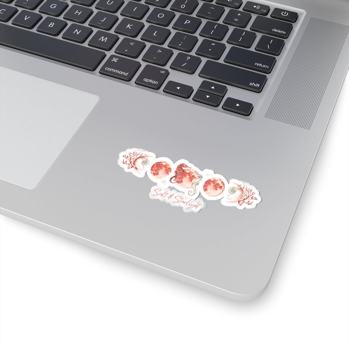 Salt & Starlight kiss-cut sticker with seahorse and coral moon phase design, shown on a laptop